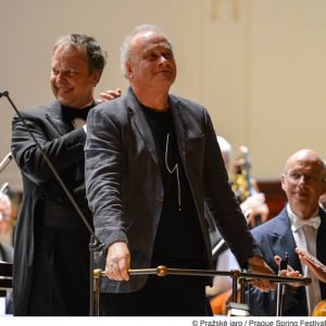 Colin Matthews taking a bow on the stage, with conductor Sakari Oramo behind him