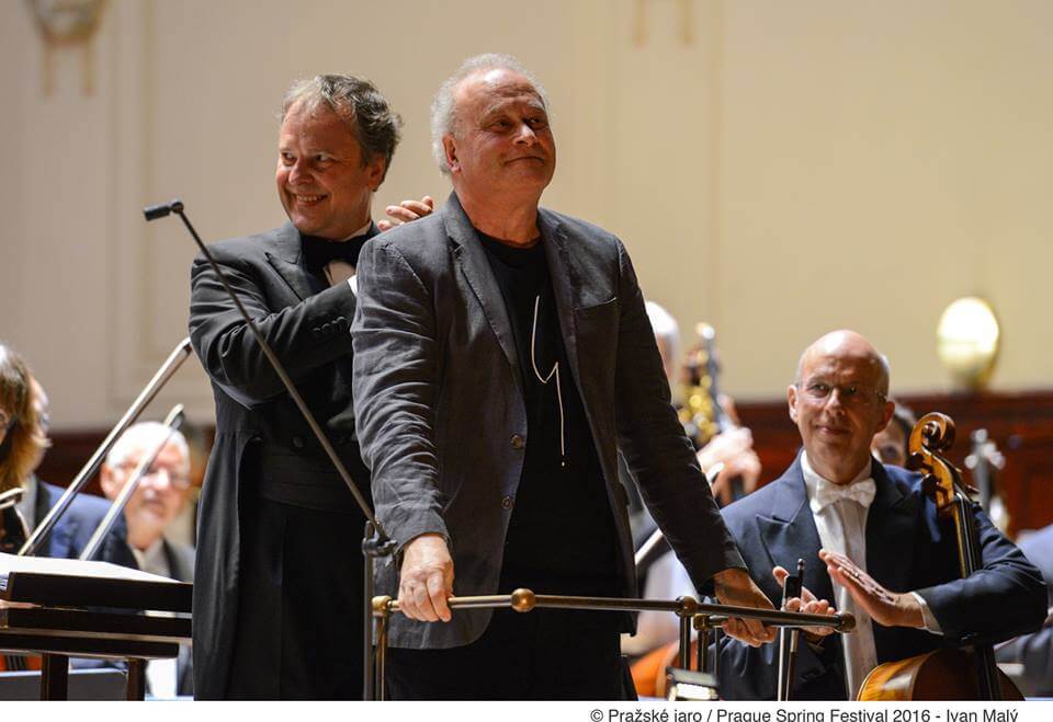Colin Matthews taking a bow on the stage, with conductor Sakari Oramo behind him