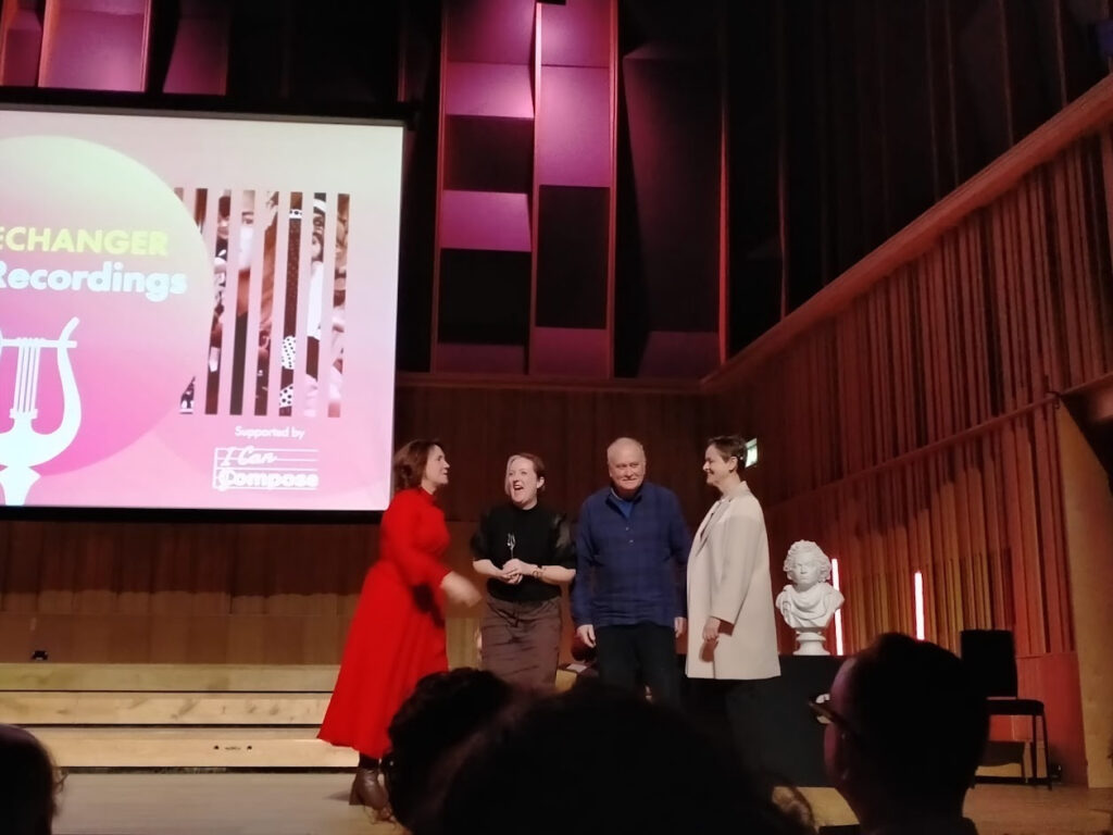 Four people on stage receiving an award