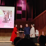 Four people on stage receiving an award