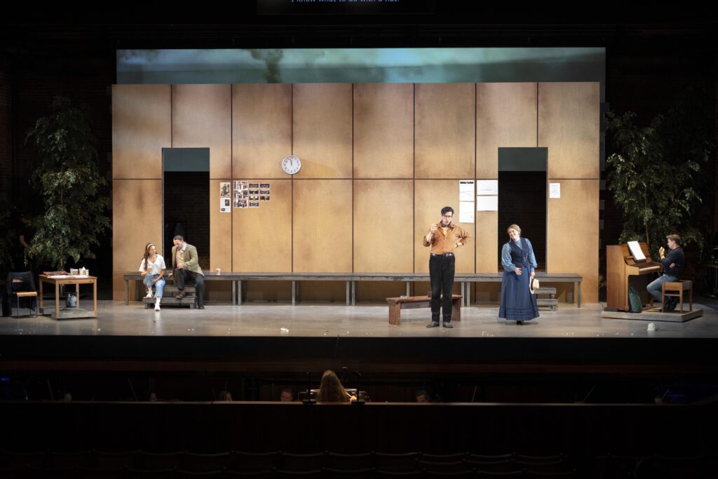 5 opera singers on stage - the set is an opera rehearsal room