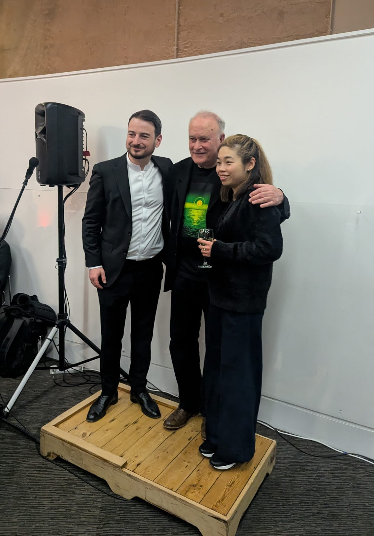 Colin Matthews, Olivier Stankiewicz and Elim Chan posing for a photo on a small platform